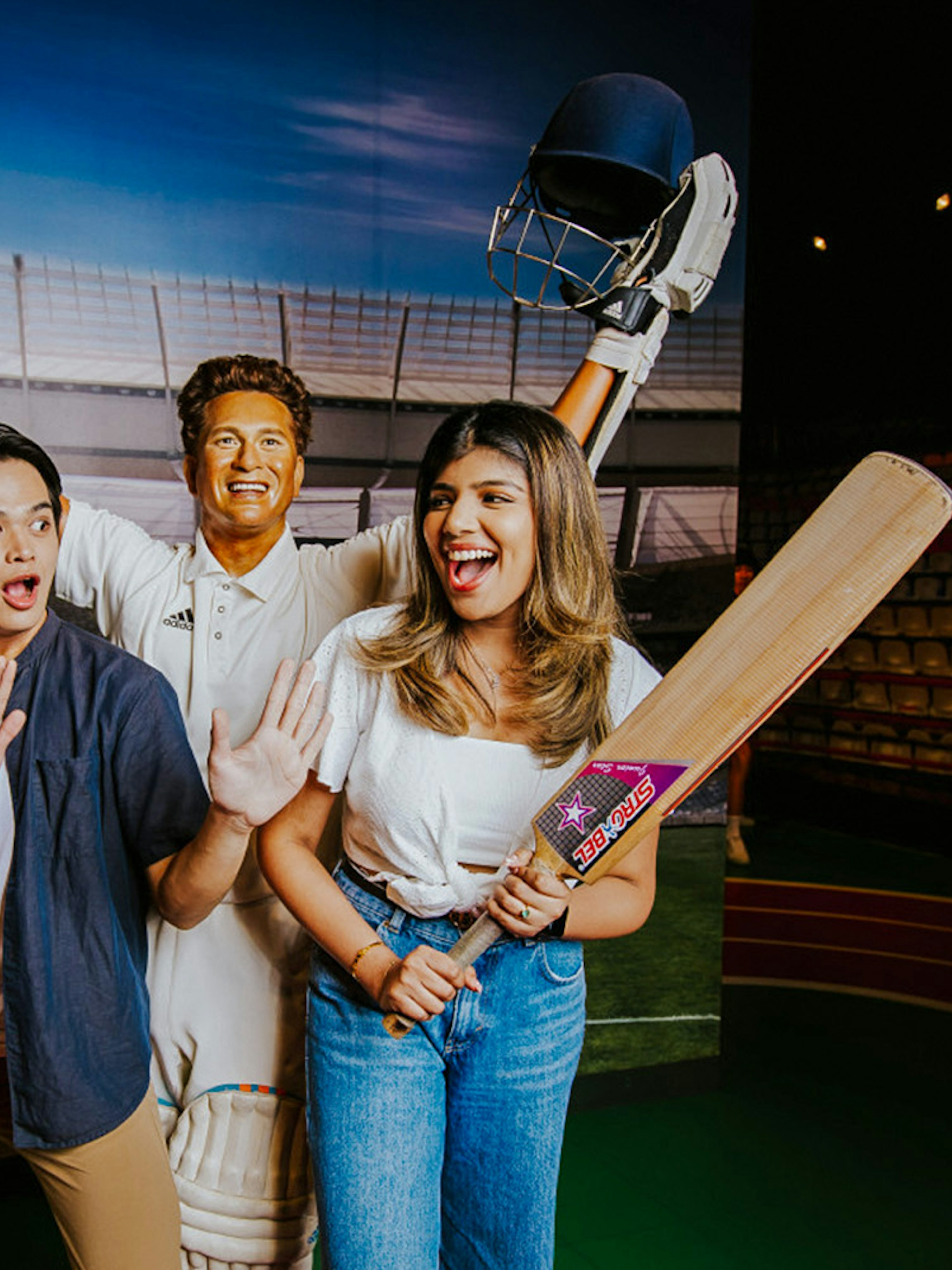 Sachin Tendulkar wax figure with visitors at Madame Tussauds Singapore.
