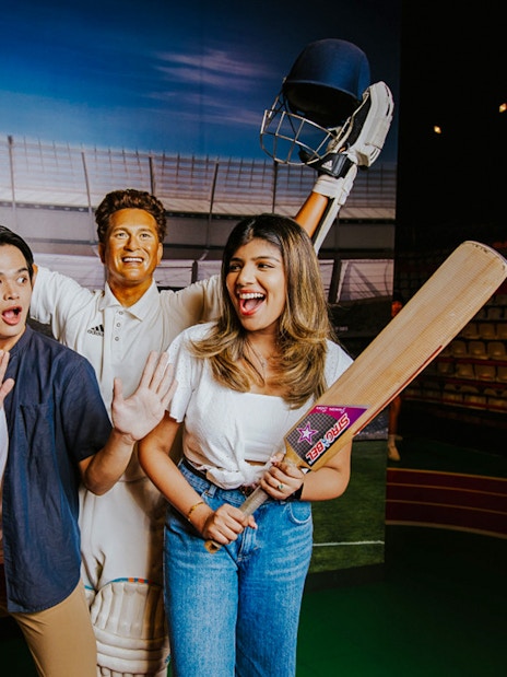 Sachin Tendulkar wax figure with visitors at Madame Tussauds Singapore.