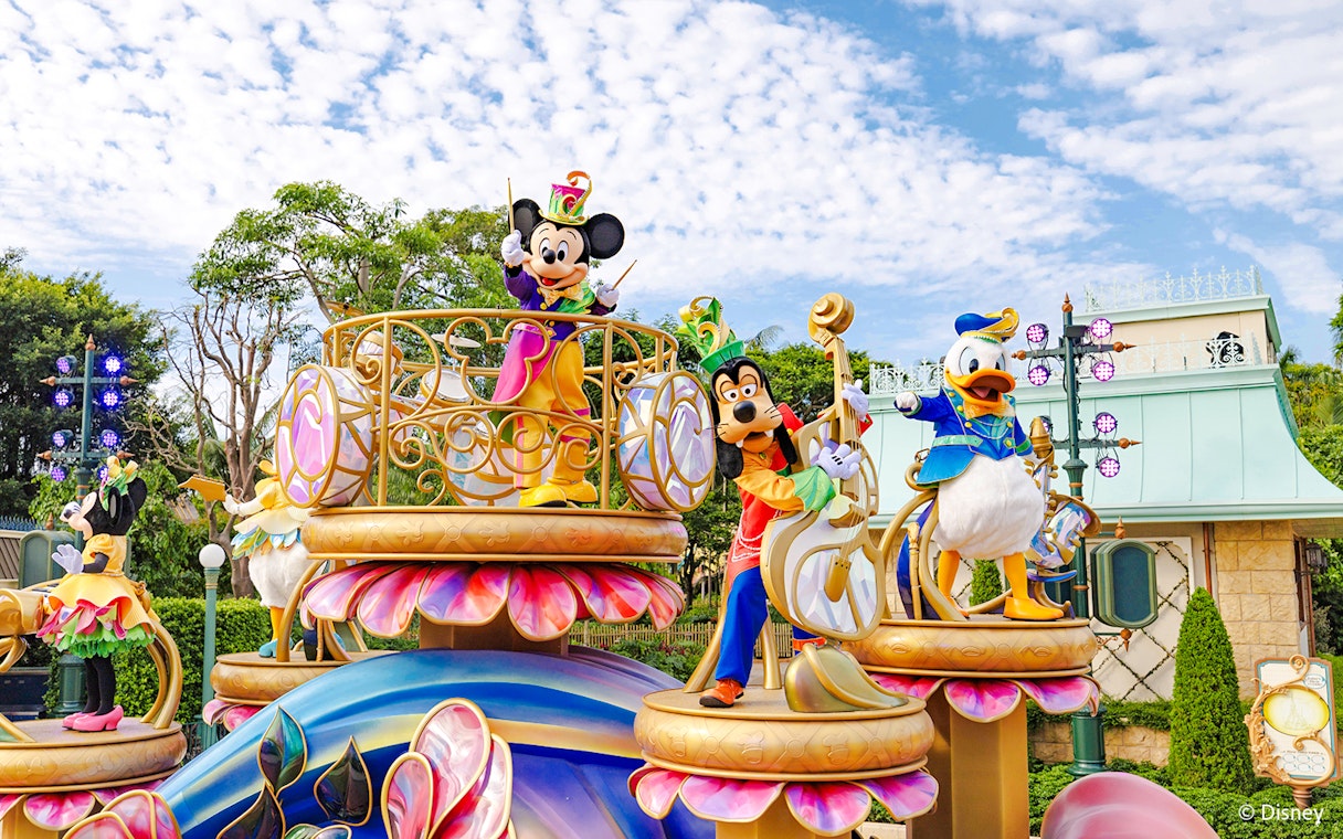 Disney characters on a colorful float during a parade at Disneyland Hong Kong.