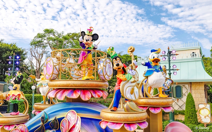 Disney characters on a colorful float during a parade at Disneyland Hong Kong.