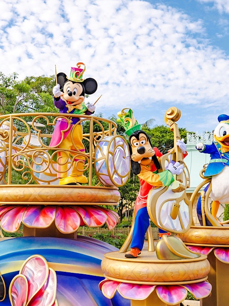 Disney characters on a colorful float during a parade at Disneyland Hong Kong.