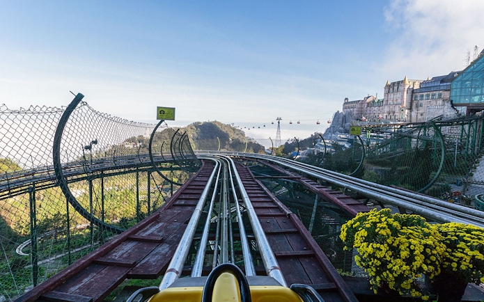 Alpine Coaster track view at Ba Na Hills with cable cars and mountain scenery.