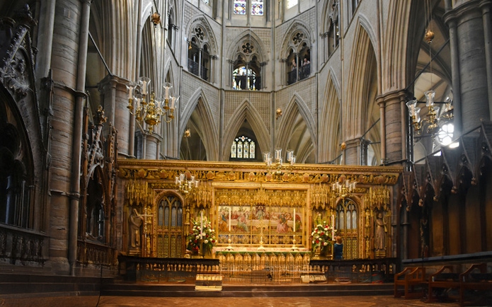 Interiors of Westminster Abbey with ornate altar and vaulted ceilings.