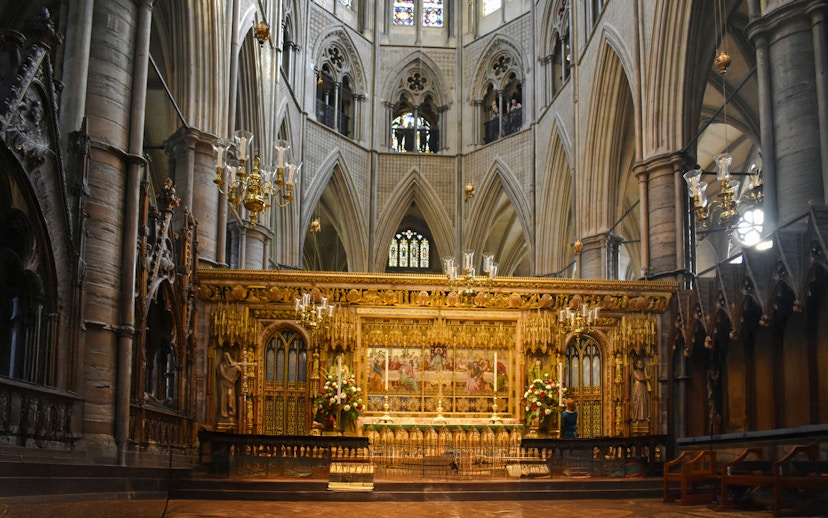 Interiors of Westminster Abbey with ornate altar and vaulted ceilings.