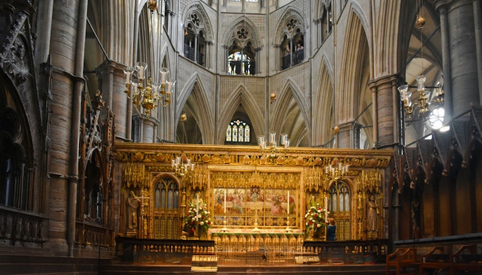 Interiors of Westminster Abbey with ornate altar and vaulted ceilings.