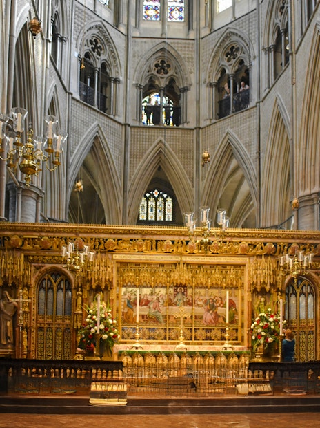 Interiors of Westminster Abbey with ornate altar and vaulted ceilings.