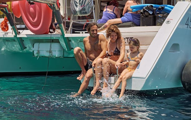 Family enjoying a catamaran cruise near Spinalonga, Crete.