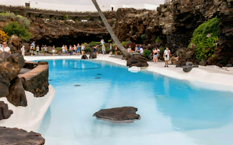 Visitors exploring the volcanic cave pool at Jameos del Agua, Lanzarote.