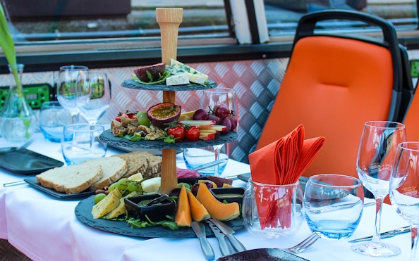 Amsterdam canal cruise table with wine glasses, cheese, and fruit platter.