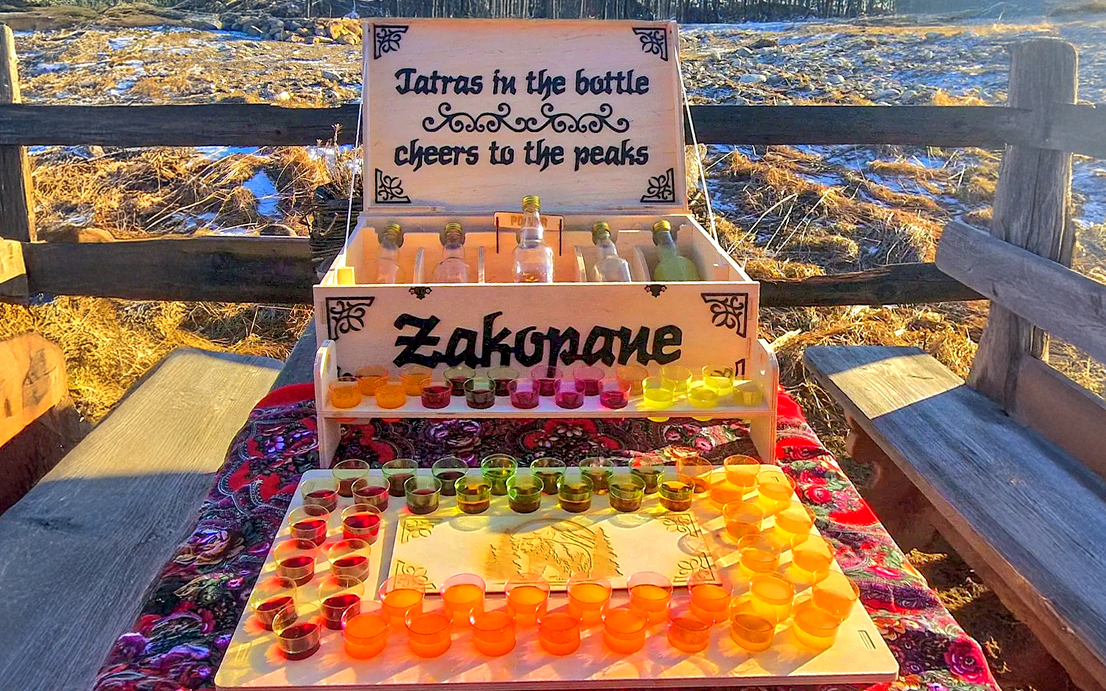 Vodka tasting setup in Zakopane with colorful shot glasses and bottles on display.