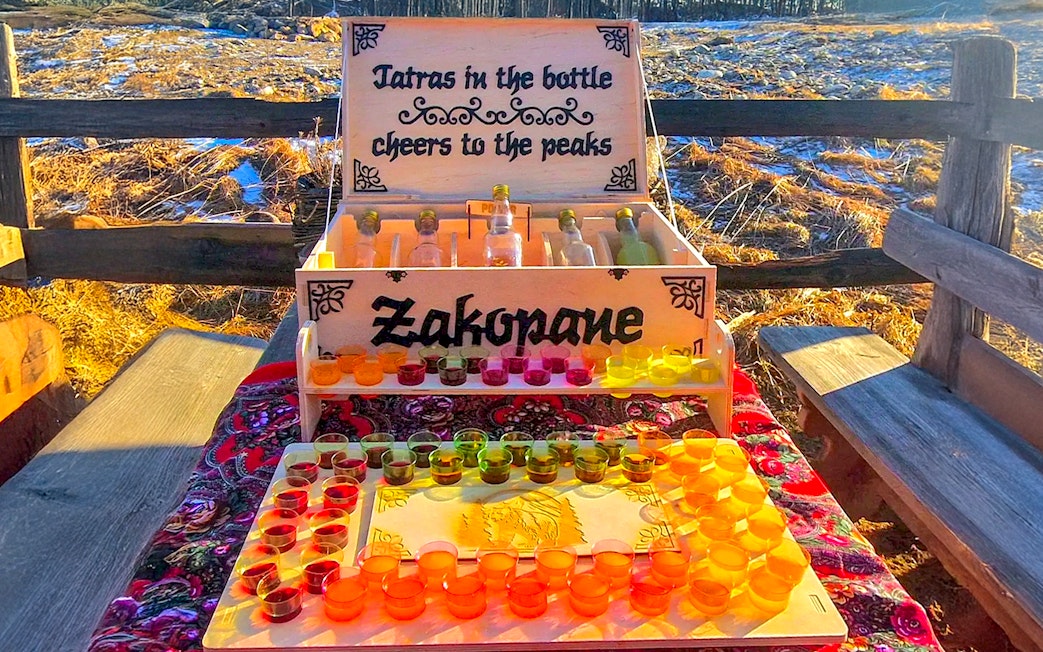 Vodka tasting setup in Zakopane with colorful shot glasses and bottles on display.