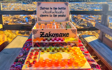Vodka tasting setup in Zakopane with colorful shot glasses and bottles on display.