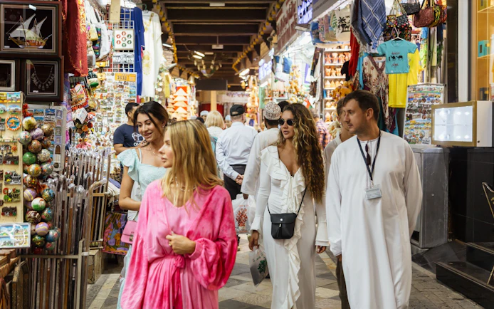 Tourists exploring Muttrah Souk in Oman, surrounded by colorful market stalls.