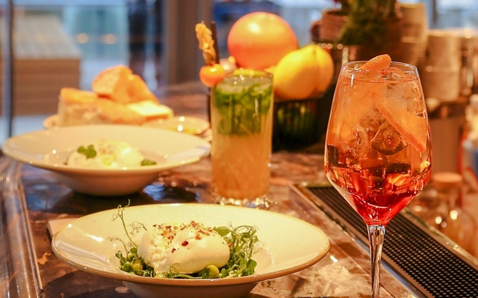 Dinner setting with burrata salad and cocktails at The Larch, Sky Garden London.
