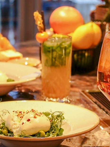 Dinner setting with burrata salad and cocktails at The Larch, Sky Garden London.