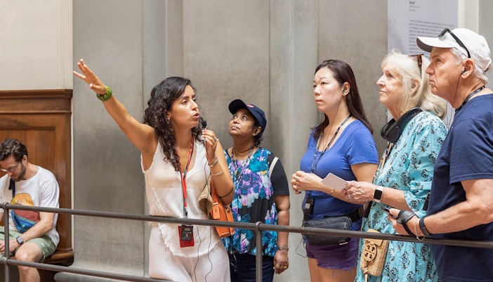 Tour group listening to guide inside liria palace