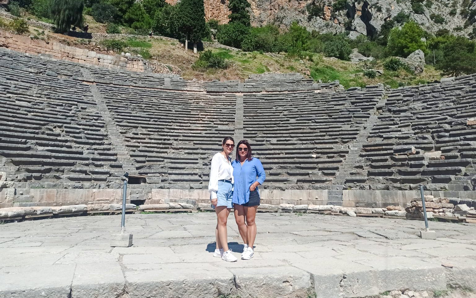 Visitors standing in front of the Ancient Theatre of Delphi, Greece.