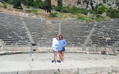 Visitors standing in front of the Ancient Theatre of Delphi, Greece.