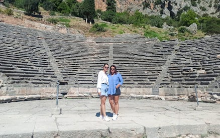 Visitors standing in front of the Ancient Theatre of Delphi, Greece.