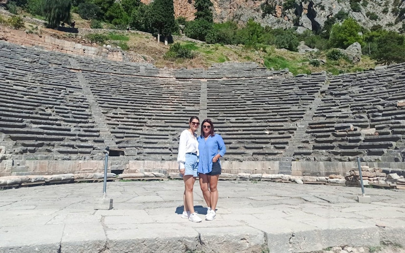 Visitors standing in front of the Ancient Theatre of Delphi, Greece.