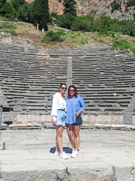 Visitors standing in front of the Ancient Theatre of Delphi, Greece.