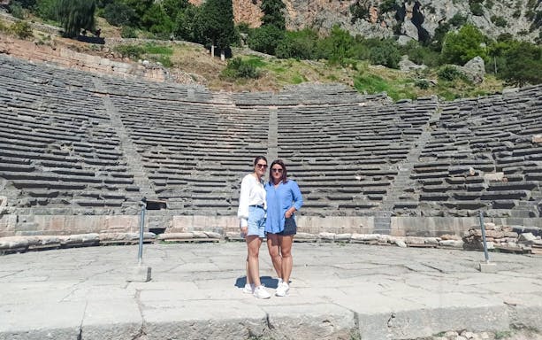 Visitors standing in front of the Ancient Theatre of Delphi, Greece.