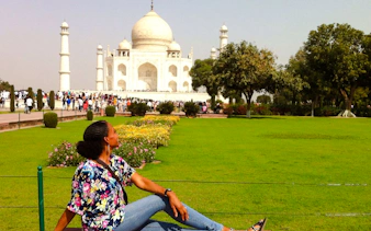 Visitor relaxing on a bench with the Taj Mahal in the background, Agra tour.