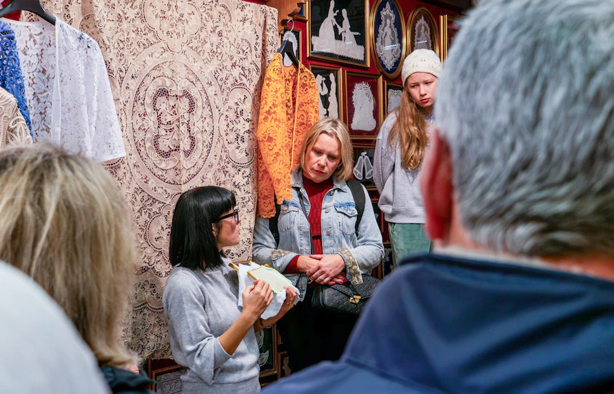 Tour group observing lace-making demonstration at Lace Museum in Burano.