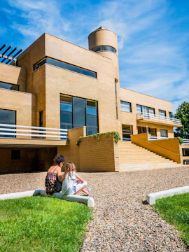 Visitors sitting outside Villa Cavrois, a modernist architectural landmark in France.