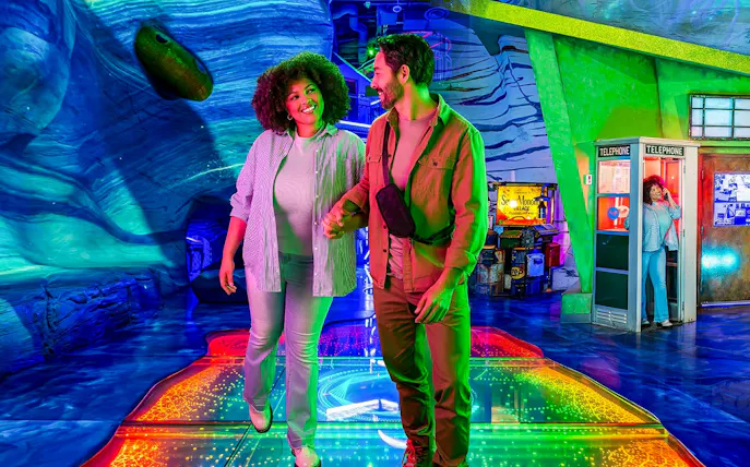 Couple exploring colorful interactive exhibit at Omega Mart, Las Vegas.