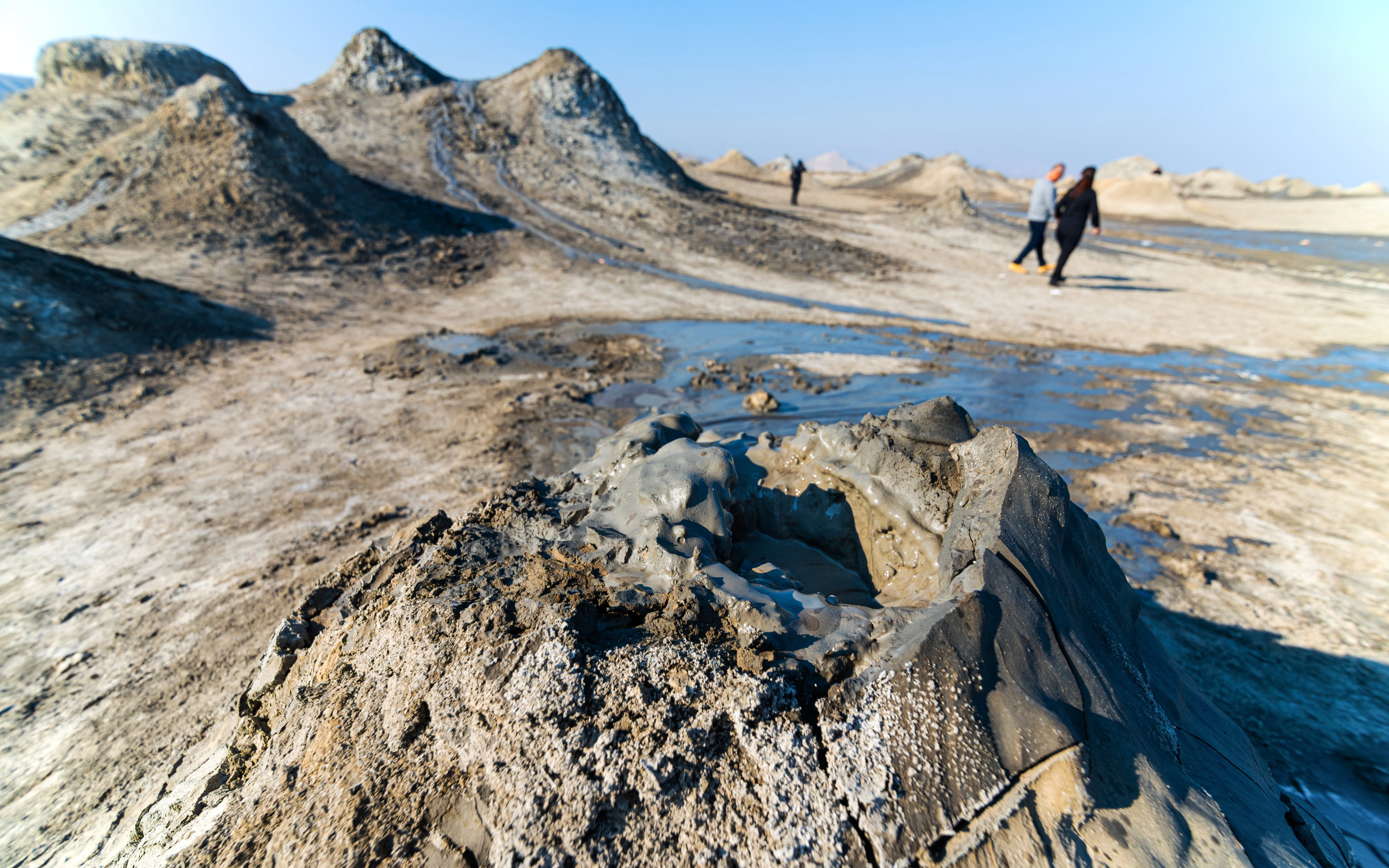 Mud volcano with tourists walking in Gobustan National Park, Azerbaijan.