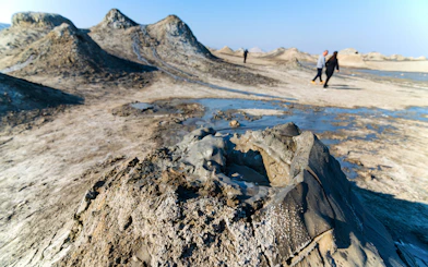 Mud volcano with tourists walking in Gobustan National Park, Azerbaijan.