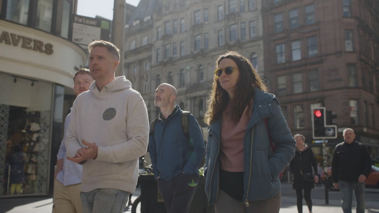 Group of people on a walking city tour in Glasgow's historic district.