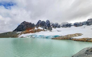 Ojo del Albino Glacier with turquoise lake and snow-covered mountains in Ushuaia, Argentina.