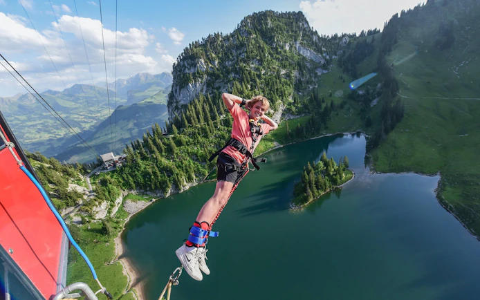 Bungee jumper over Stockhorn Interlaken with alpine lake and mountains in view.