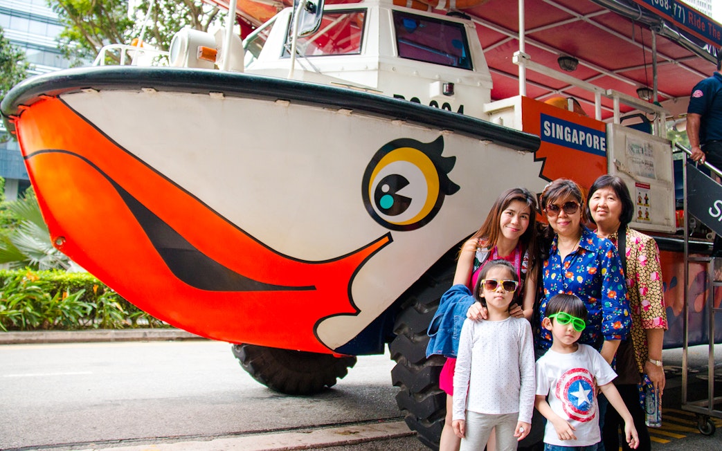 DUCKtours Singapore vehicle with a family posing in front.