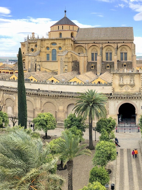 Córdoba Cathedral-Mosque entrance with courtyard and palm trees.