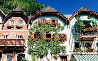 Colorful traditional houses with flower boxes in Hallstatt, Austria, seen on a day trip from Vienna.