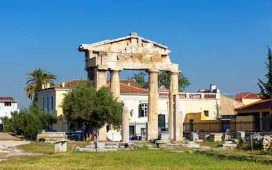 Ancient Greek columns at Roman Agora, Athens with surrounding buildings.
