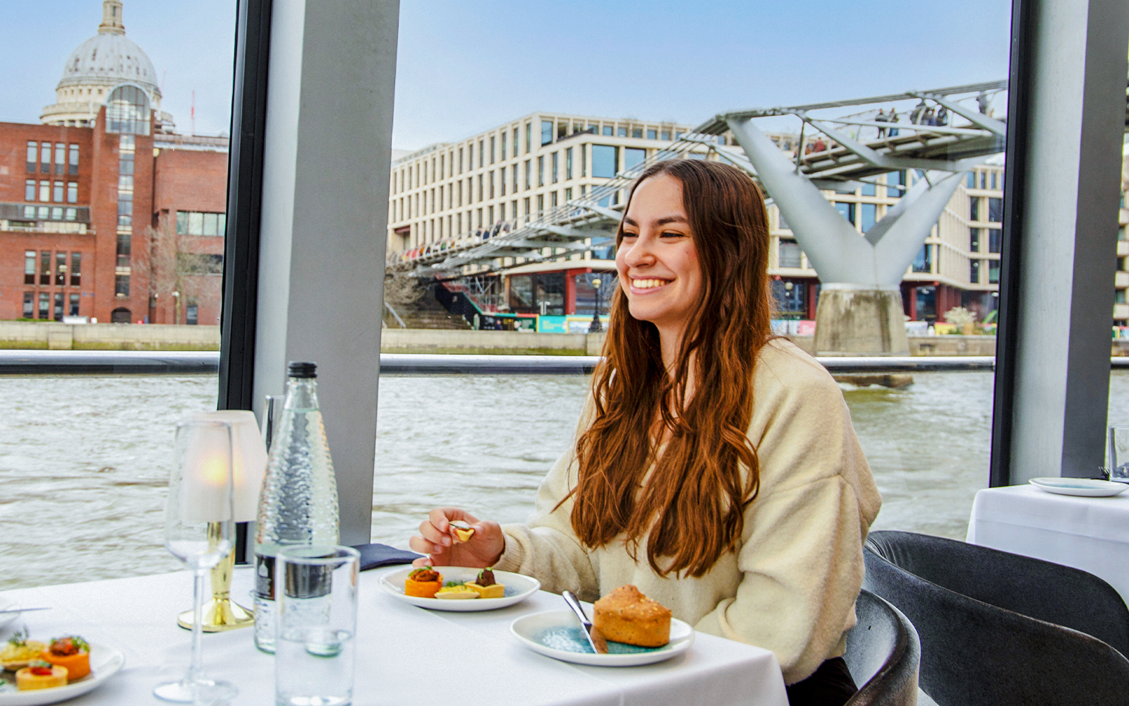 Dinner cruise on the Thames River with view of Millennium Bridge and St. Paul's Cathedral.
