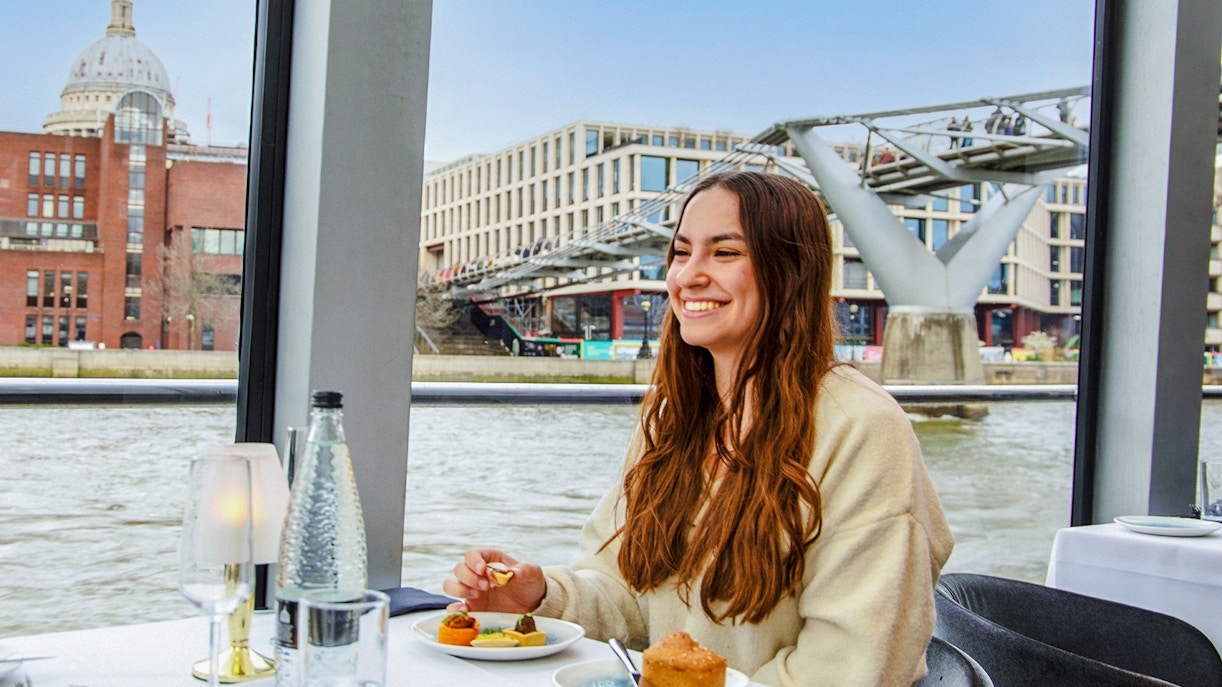 Dinner cruise on the Thames River with view of Millennium Bridge and St. Paul's Cathedral.