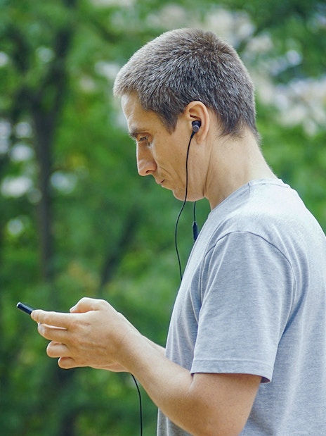 Guest using audio guide in a park setting.