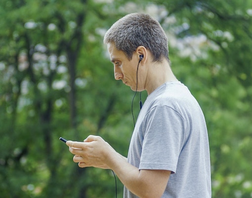 Guest using audio guide in a park setting.