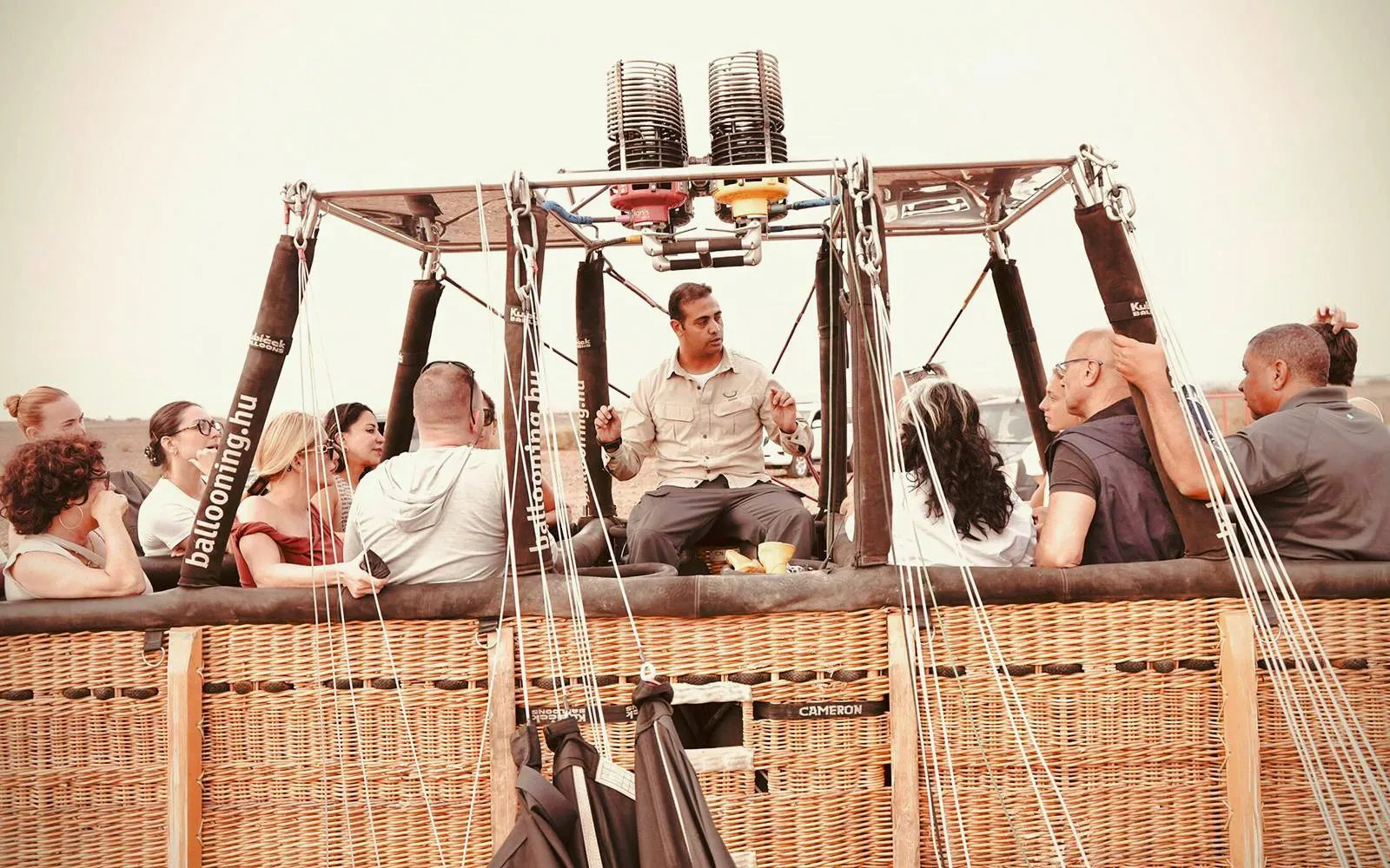 Hot air balloon passengers and pilot preparing for sunrise flight in Marrakech.