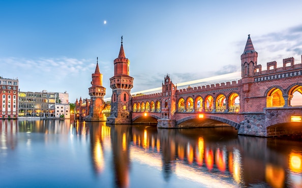 Oberbaum Bridge illuminated at dusk during Berlin evening sightseeing cruise.