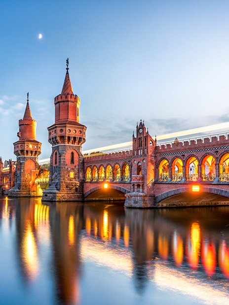 Oberbaum Bridge illuminated at dusk during Berlin evening sightseeing cruise.