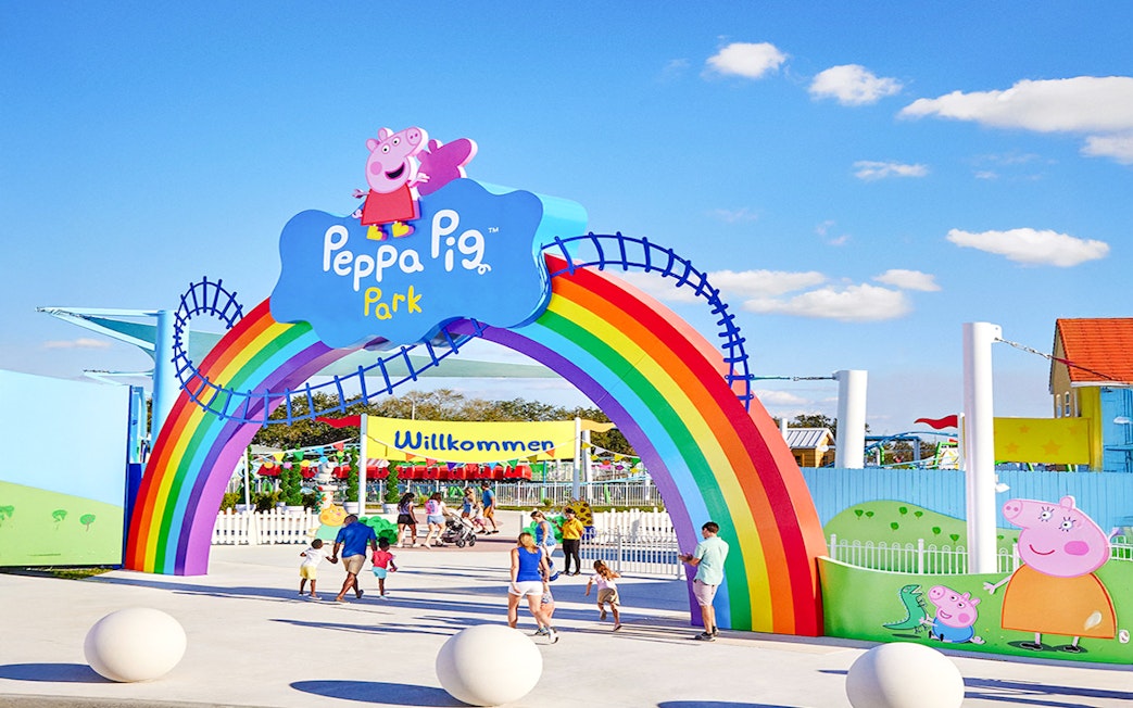 Entrance to Peppa Pig Park in Guntzburg with rainbow arch and families entering.