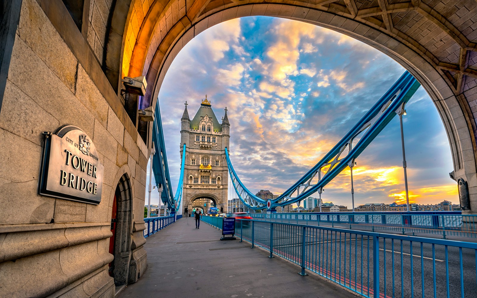 Tower Bridge in London at sunset, viewed from under an archway.