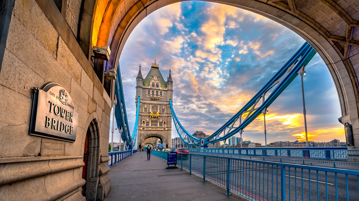Tower Bridge in London at sunset, viewed from under an archway.