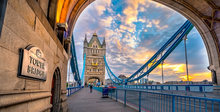 Tower Bridge in London at sunset, viewed from under an archway.